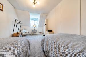 a bedroom with a bed and a chair and a window at Old Rectory Cottage, Tostock in Tostock