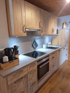 a kitchen with wooden cabinets and a sink at Winklern Appartment Wildschütz in Kitzbühel