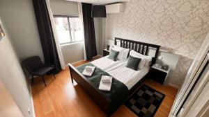 a bedroom with a bed and a chair and a window at Apartment Alpha - 2 Bedrooms, Private Rooftop Patio with Hot Tub, BBQ and View in Ferragudo