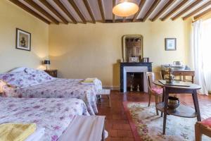 a bedroom with two beds and a fireplace at Gîte de Pierre in Champlin