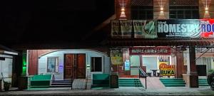 a house with signs on the side of it at night at KASMA HOMEsTELs in Kampong Permaisuri