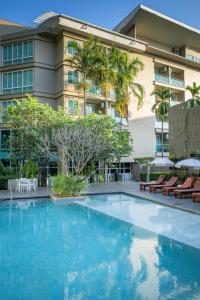 a large swimming pool in front of a building at Peach Hill Resort - SHA Extra Plus in Kata Beach
