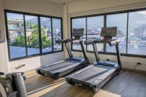 three treadmills in a gym with windows at Peach Hill Resort - SHA Extra Plus in Kata Beach