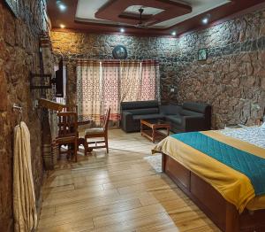 a bedroom with a bed and a couch and a table at Vaga Copper Castle in Vagamon