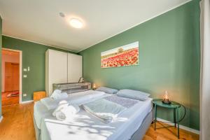 a bedroom with a large bed and a green wall at Lüftenblick - 2 Ferienwohnungen am Starnberger See, mit Terrasse oder Balkon, Weitblick, Sauna, Kamin, E-Ladestation in Berg am Starnberger See