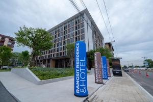 eine Reihe von Schildern vor einem Gebäude in der Unterkunft Rangsit Residence & Hotel by HOTEL DD in Ban Talat Rangsit