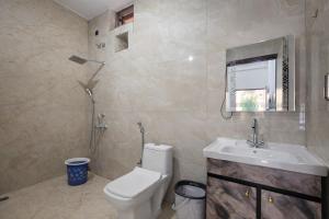 a bathroom with a toilet and a sink at Forest Nest Farm Stay in Rājpur