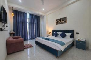 a bedroom with a king sized bed and a chair at Forest Nest Farm Stay in Rājpur +12 photos