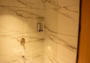 a shower with marble walls and a glass door at Magnus Lxia Premier, Kalyani Nagar Pune in Pune +39 photos