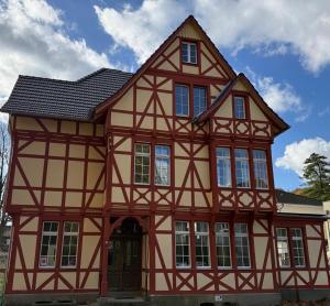 a half timbered house with a black roof at Mariene Home Apartments - Am Hammer in Rösrath