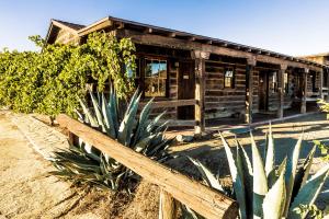 
a large wooden building with a large wooden fence around it at Pioneertown Motel in Pioneertown
