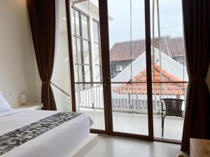 a bedroom with a bed and a large window at Ramady Guest House in Tumbak Bayuh