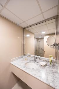 a bathroom with a sink and a large mirror at Golden Sands Hotel Apartments in Dubai