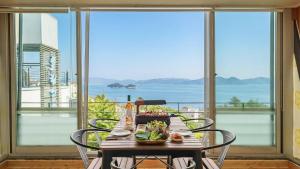 a table with food on it in front of a window at Yeosu falling in blue ocean view pension in Yeosu +2 photos