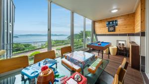 a living room with a pool table and a view of the ocean at Yeosu falling in blue ocean view pension in Yeosu