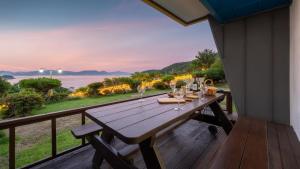 a wooden table on a deck with a view of the ocean at Yeosu falling in blue ocean view pension in Yeosu