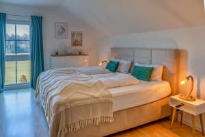 a bedroom with a large bed and a window at Lüftenblick - 2 Ferienwohnungen am Starnberger See, mit Terrasse oder Balkon, Weitblick, Sauna, Kamin, E-Ladestation in Berg am Starnberger See
