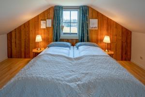 a bedroom with a large bed and two lamps at Lüftenblick - 2 Ferienwohnungen am Starnberger See, mit Terrasse oder Balkon, Weitblick, Sauna, Kamin, E-Ladestation in Berg am Starnberger See