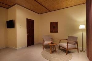 a living room with two chairs and a table and a television at Selau Asry in Sidemen