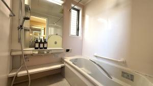 a bathroom with a tub and a sink and a mirror at kamakura retreatB in Kamakura +17 photos