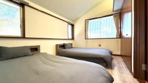 a bedroom with two beds and two windows at kamakura retreatB in Kamakura