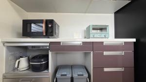 a kitchen with a counter with a microwave and appliances at kamakura retreatB in Kamakura