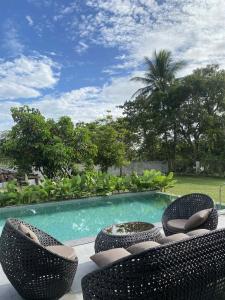 a swimming pool with two chairs and a table and a swimming pool at Solunara Malolos in Malolos