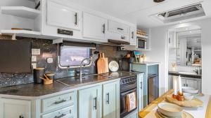 a kitchen with white cabinets and a sink at Vineyard Farmstay in Clare