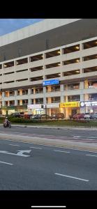 a motorcycle driving in front of a large building at JC COZYsTAY RAWANG in Rawang