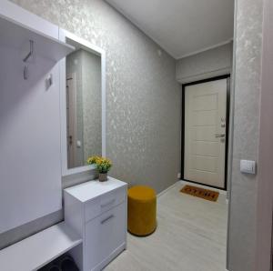 a bathroom with a sink and a mirror and a yellow stool at Aizhan Bekshenova in Lenīnogorsk
