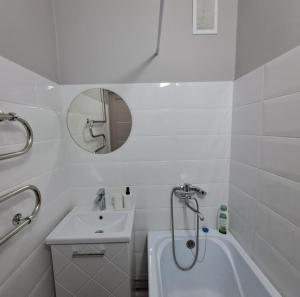 a white bathroom with a sink and a shower at Aizhan Bekshenova in Lenīnogorsk