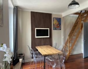 a dining room with a table and chairs and a television at Le charme de Collioure in Collioure