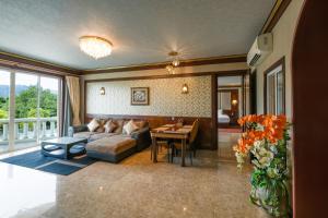 a living room with a couch and a table at Erawan Phangnga Hotel, Natai Beach in Ban Na Phong +116 photos