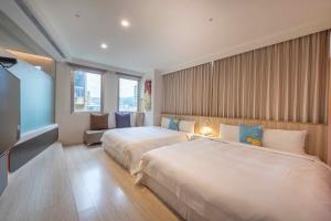 ein Hotelzimmer mit zwei Betten und einem Fernseher in der Unterkunft No. 9 Hotel in Jiaoxi + 34 Fotos