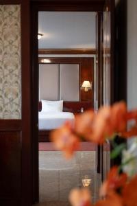 a view of a bedroom with a bed and a mirror at Erawan Phangnga Hotel, Natai Beach in Ban Na Phong