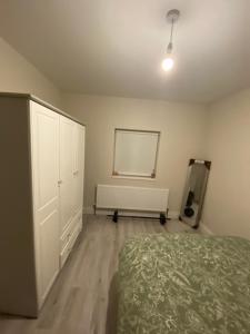 a bedroom with a bed and a white cabinet at Big Town Charm in Drogheda