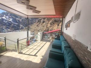 a balcony with a couch and a view of a mountain at Hotel Yamuna palace in Kharsālī