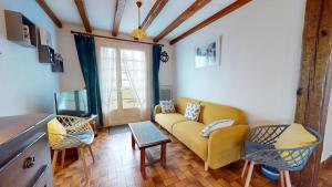 a living room with a yellow couch and chairs at Villa des Oceanides in Saint-Gilles-Croix-de-Vie