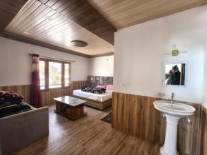 a bathroom with a bed and a sink in a room at Hotel Yamuna palace in Kharsālī