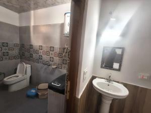 a small bathroom with a sink and a toilet at Hotel Yamuna palace in Kharsālī