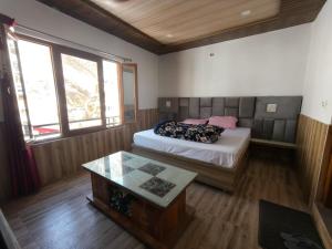 a bedroom with a bed and a table in it at Hotel Yamuna palace in Kharsālī +17 photos