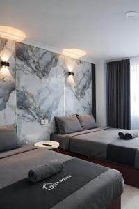 a hotel room with two beds and a marble wall at Neela House in Labuan +35 photos