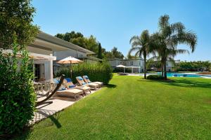 a yard with chairs and an umbrella and a pool at Azure Villas By Cornelia in Belek