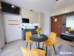 a kitchen and dining room with a table and chairs at 365PAM - Studio Dominikańska Szóstka - Z PARKINGIEM W CENIE, KRYTY BASEN W OBIEKCIE in Sianozety