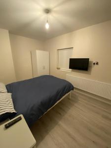 a bedroom with a bed and a flat screen tv at Big Town Charm in Drogheda