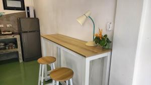 a small kitchen with a counter with stools and a lamp at Feel home Private Studio in Ko Phangan