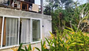 a house with sliding glass doors and a balcony at Feel home Private Studio in Ko Phangan