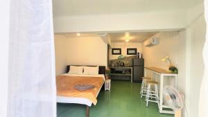 a small room with a bed and a kitchen at Feel home Private Studio in Ko Phangan