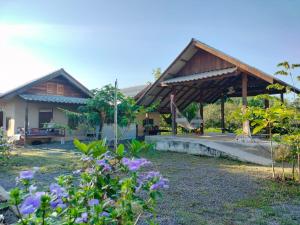a house with a pavilion in a yard with flowers at Little Forest Chiang Mai in Chiang Mai