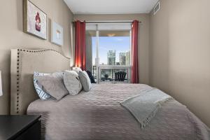 a bedroom with a bed and a window with a view at GlobalStay Downtown Calgary Condos in Calgary